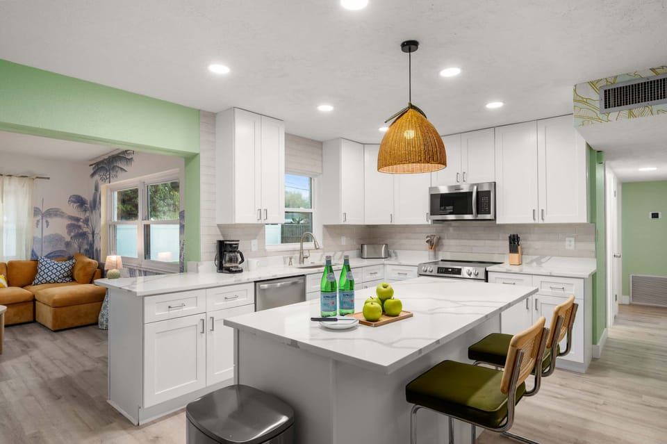 Bright kitchen w/ white cabinets, island & pendant lighting.

