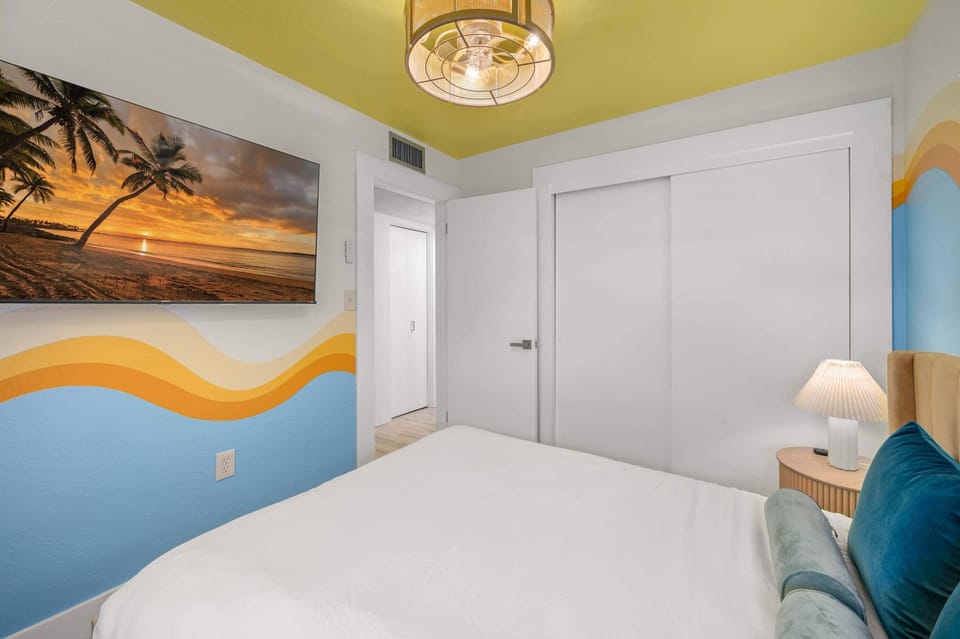 Retro-chic bedroom w/ wavy wall art & warm sunset-toned décor.
