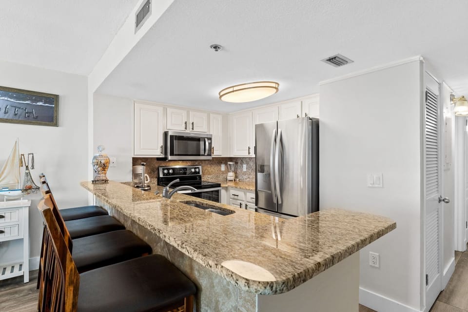 The kitchen features modern appliances and a convenient breakfast bar that offers extra seating and a great spot for quick meals.