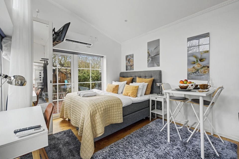 Full studio layout featuring a king-size bed, small dining area, workspace, and direct access to the private fenced terrace. Compact, calm, and ideal for two.