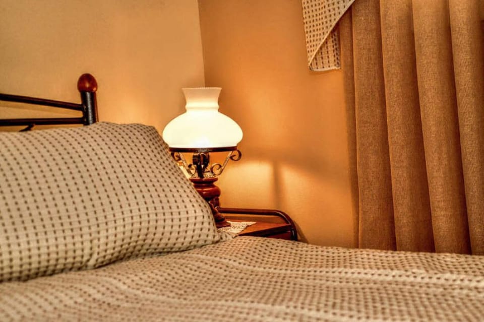 Bedroom detail showing traditional bedding and soft lighting that creates a cozy environment for a comfortable stay.