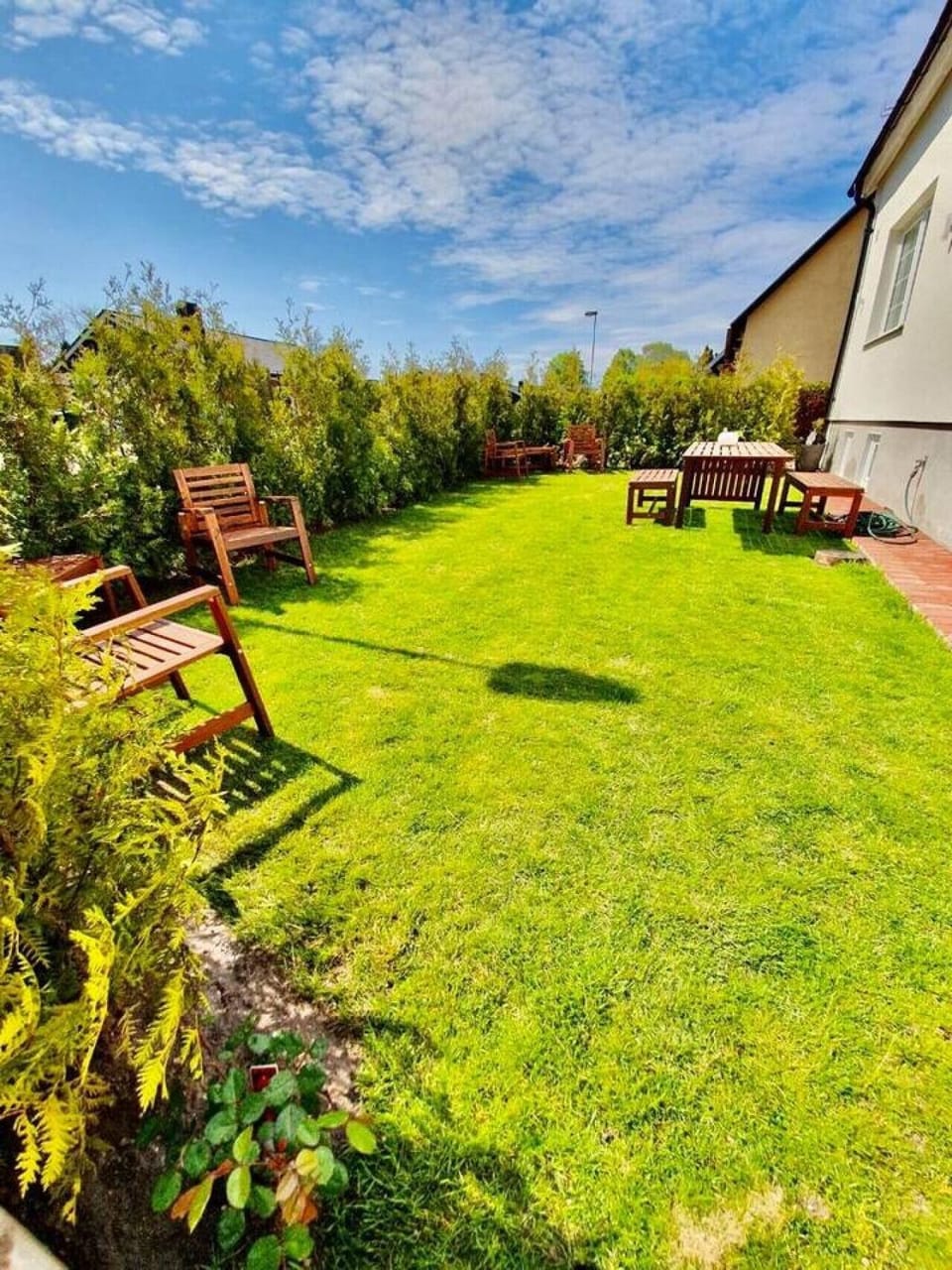 Shared outdoor garden space with seating and dining area, ideal for relaxed family evenings.