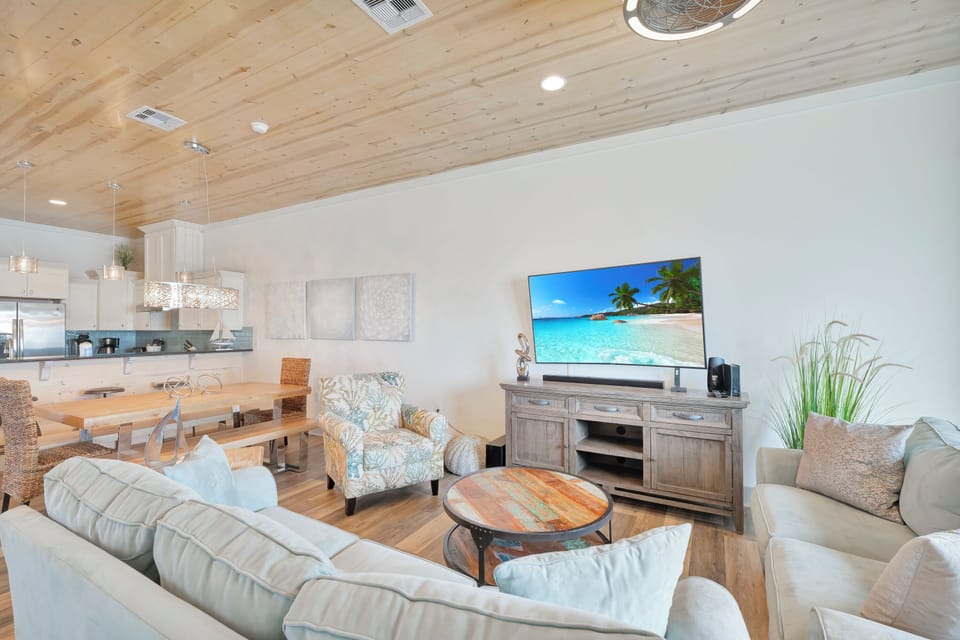 Sink into plush sofas in your bright, airy living space where modern comfort meets coastal style, complete with entertainment center for cozy nights in.