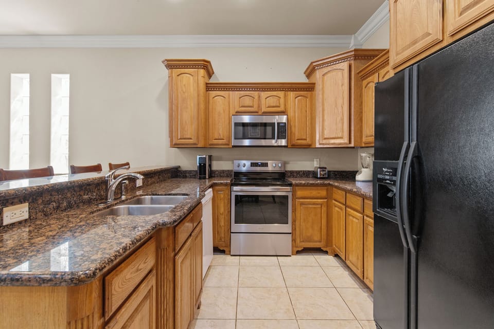 Kitchen featuring full-size appliances- refrigerator, stove, microwave, and dishwasher