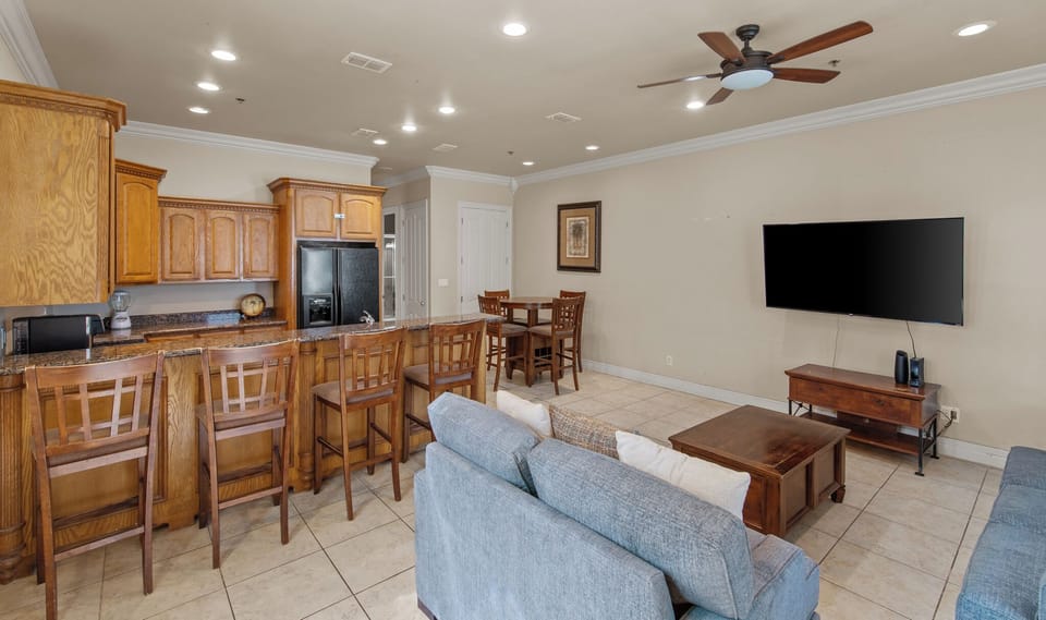 Open-concept living, dining, and kitchen area with breakfast bar seating