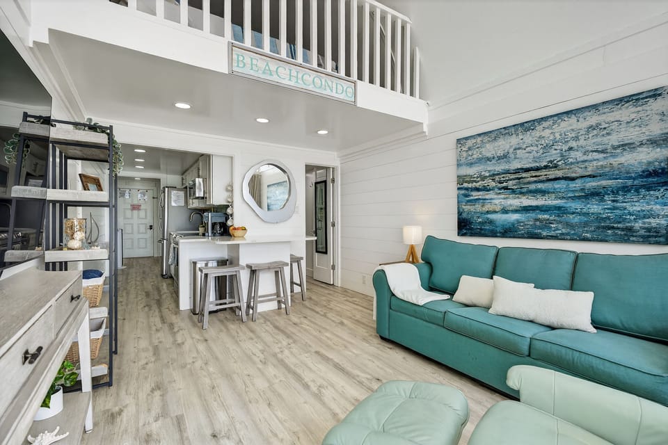 Sunny beach condo with loft, cozy lounge, and breakfast-bar kitchen