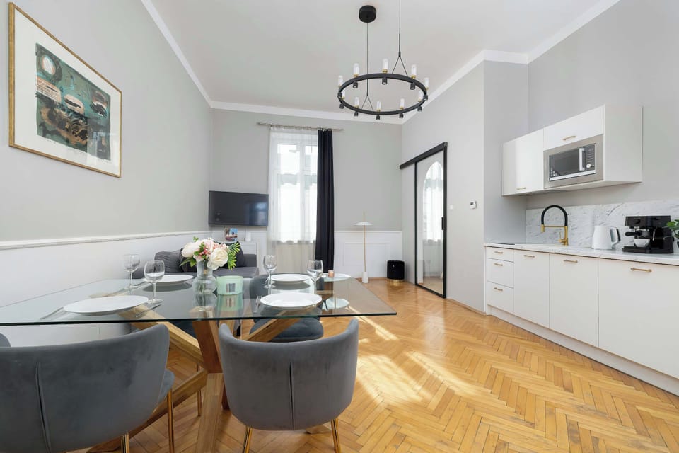 A view of the apartment's interior looking from the living area toward the kitchen. The open layout and high ceilings create a sense of space and airiness throughout the home.