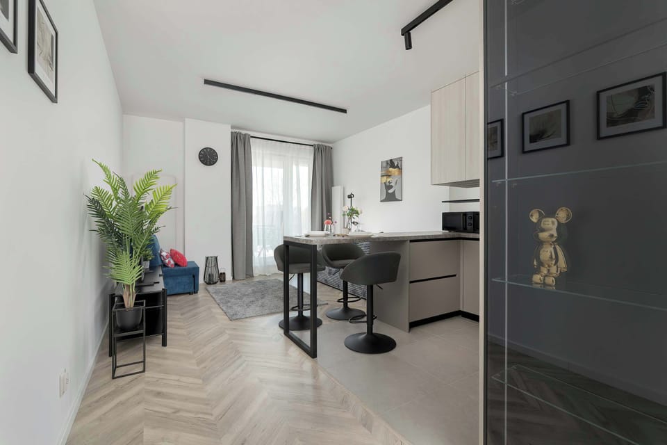 A hallway view leading into a contemporary apartment. Neutral colors dominate the decor. The space feels clean and organized.