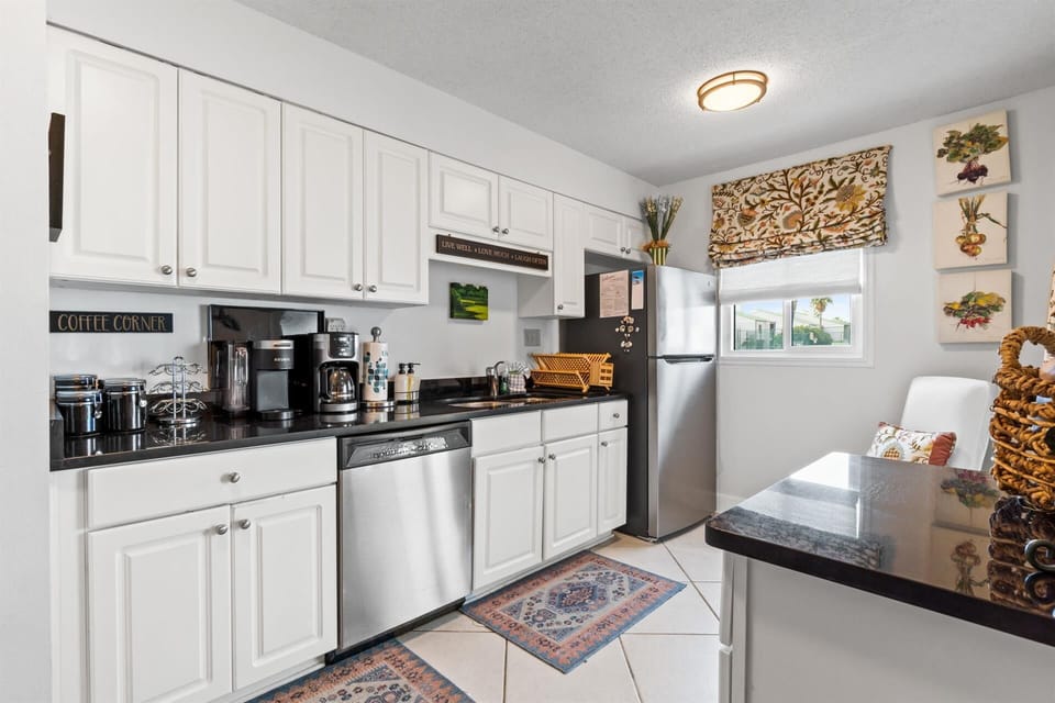 Your fully-equipped kitchen awaits with granite counters, stainless appliances, and a charming coffee corner for brewing your perfect morning cup.