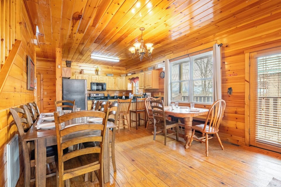 Gather around warm wooden tables in your rustic dining space, where every meal becomes a memorable moment under charming chandelier lighting.