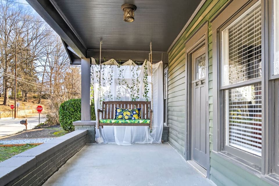 Enjoy the charming front porch swing overlooking the city street — the perfect spot for morning coffee or winding down after a fun day!
