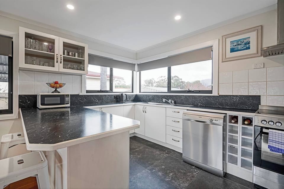 Cook up coastal feasts in the light-filled kitchen complete with a breakfast bar, oven, dishwasher, pour-over coffee setup, built-in wine rack and all the essentials for home cooking.