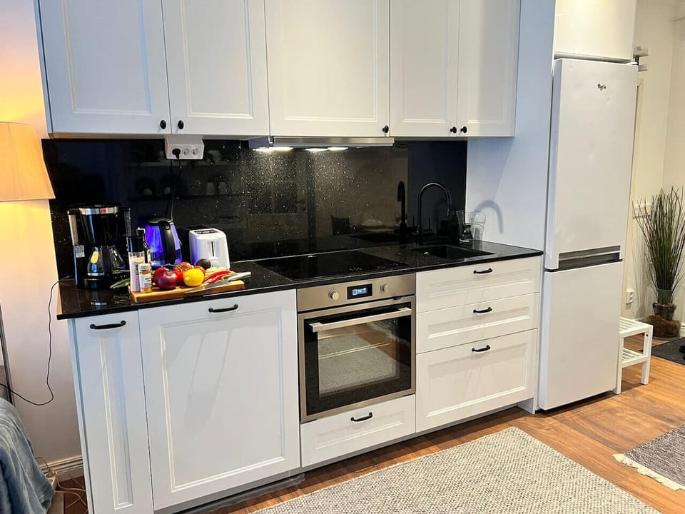 Fully equipped kitchen featuring oven, cooktop, full-size fridge freezer, sink, and small appliances for family meals.
