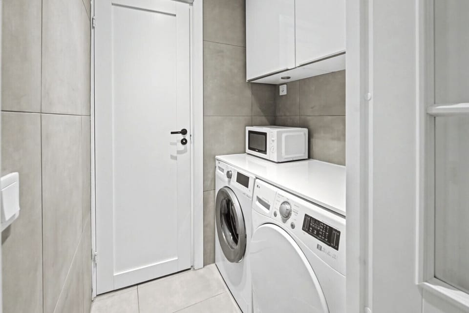 Separate laundry room featuring washer, dryer, and storage space. Ideal for families and extended stays.