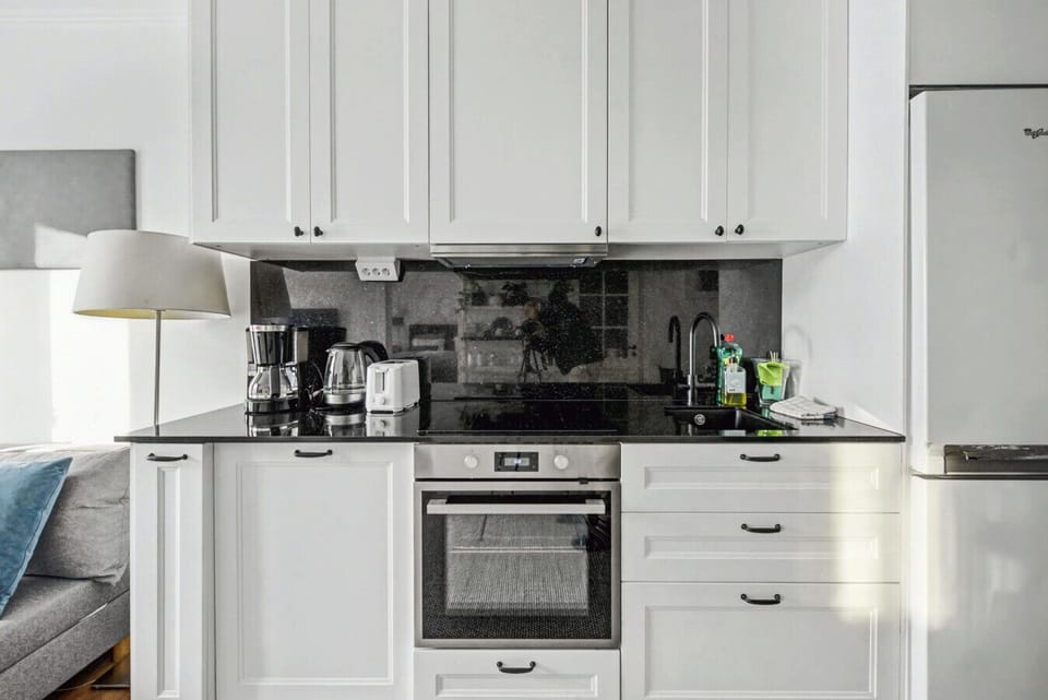 Modern kitchen featuring oven, cooktop, full-size fridge freezer, and essential appliances for convenient family meals.