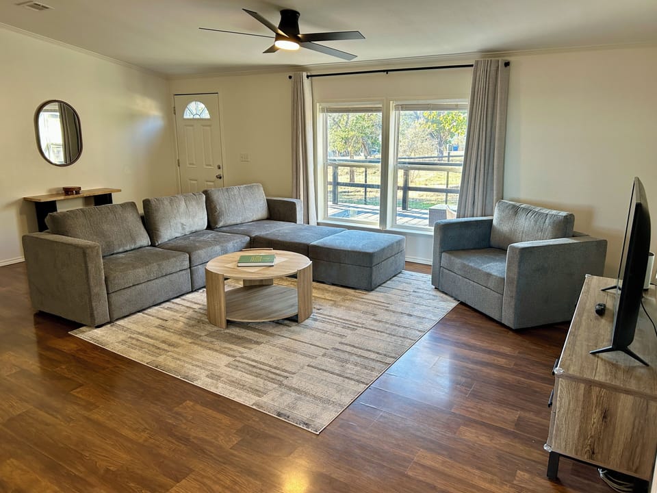 Living room with TV and futon style couch that can sleep two in an L shape.