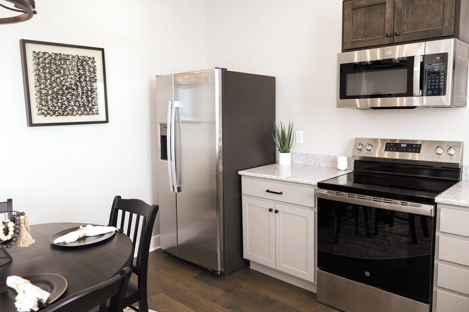 This space has a full-sized fridge, stovetop, microwave, and dishwasher.
