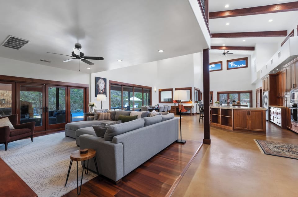 Relax in your spacious open-plan living area with soaring ceilings, warm wood beams, and modern comfort throughout.