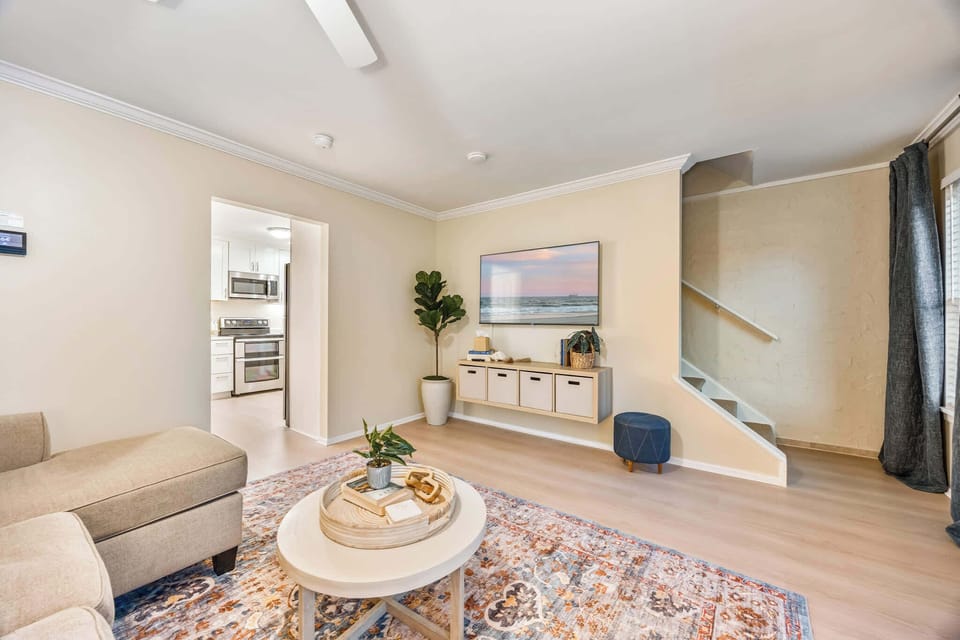 Relax in the cozy living room with a wall-mounted TV and stylish storage unit.