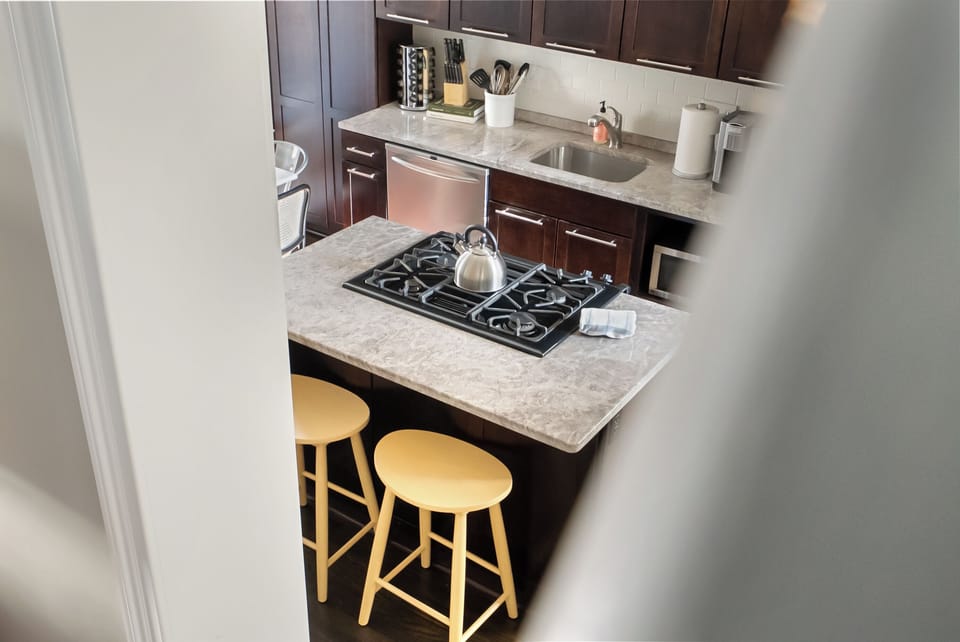 Kitchen island with bar seating and cooktop.