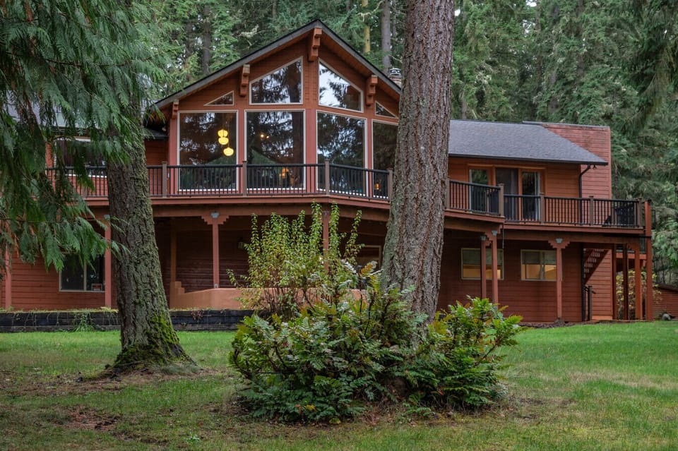 Full exterior view of the cabin showcasing expansive deck space and private wooded setting.