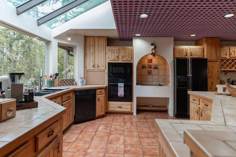 Fully equipped kitchen- modern appliances, custom wood finishes and forest views