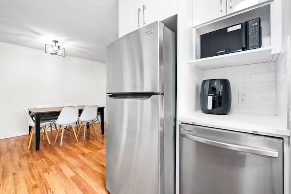 Modern kitchen with stainless steel fridge, microwave, and a handy air fryer.