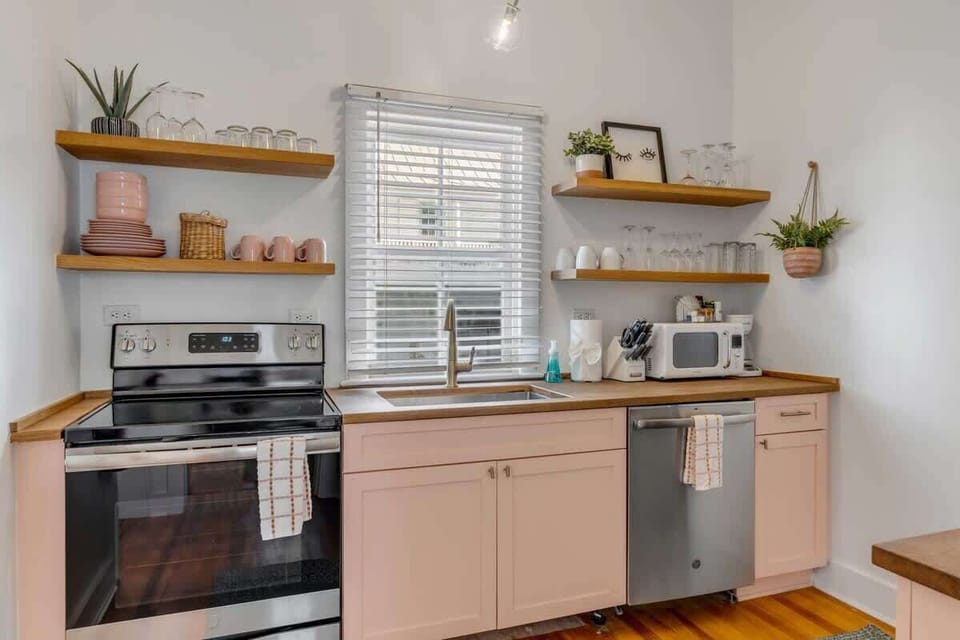 A fully stocked kitchen with modern appliances, cookware, dishes, and coffee maker for meals at home.