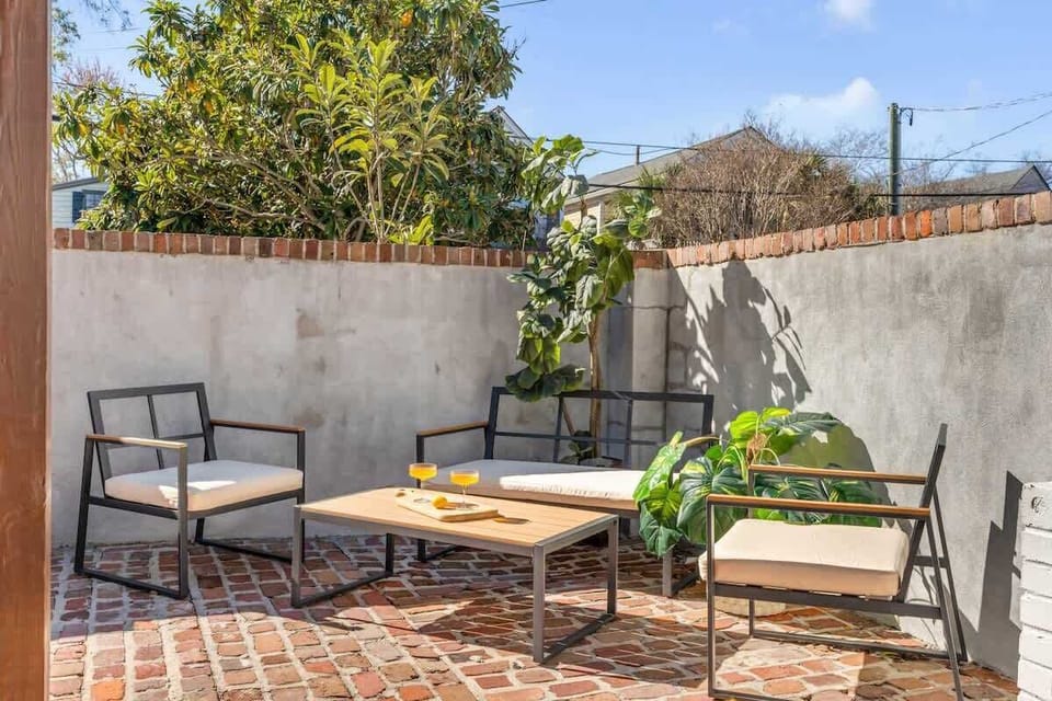 Private courtyard with outdoor fireplace, dining area, and plenty of comfortable seating.