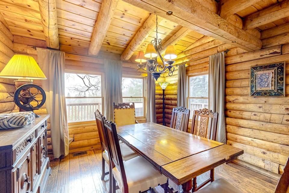 ather the whole group around this carved wood dining table beneath a warm chandelier — the kind of space made for long dinners and good conversation after a day in the mountains.