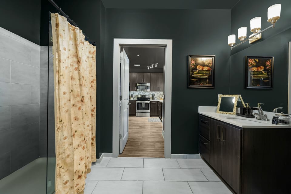 ✦ Bathroom ✦ Deep green walls, gold vanity mirror + walk-in shower, plush towels