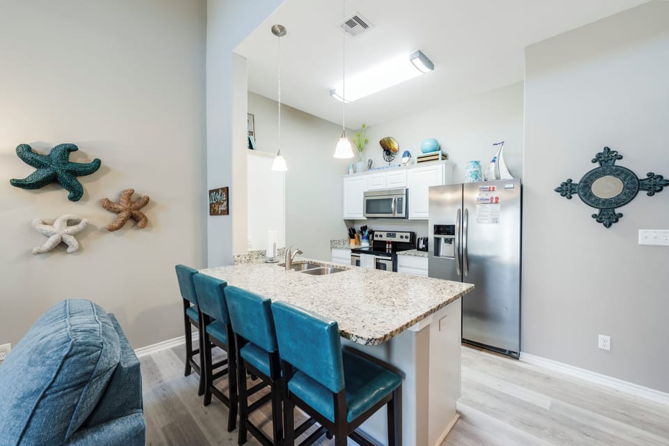 Your fully equipped kitchen invites morning coffee rituals and meal prep, with granite countertops and modern appliances creating the perfect culinary retreat.
