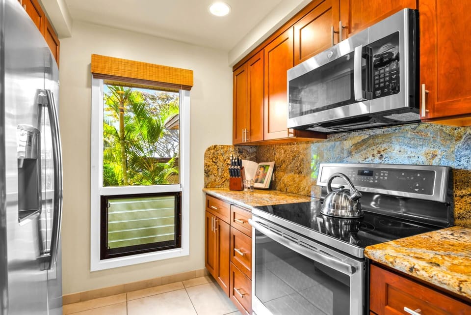 The kitchen features warm wood cabinetry and granite counters