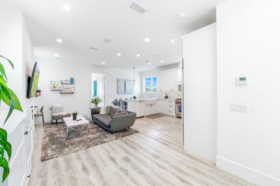 A expansive view of the main floor where the living, dining, and kitchen areas converge, featuring premium flooring and abundant recessed lighting.