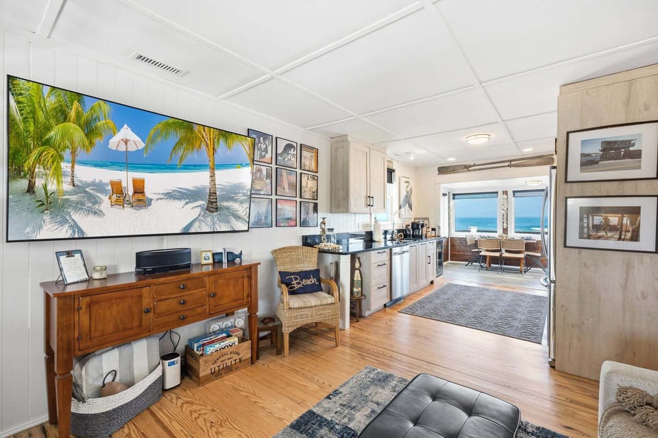 The bright and airy living room offers a comfortable gathering space where guests can relax together after a full day of beach adventures.
