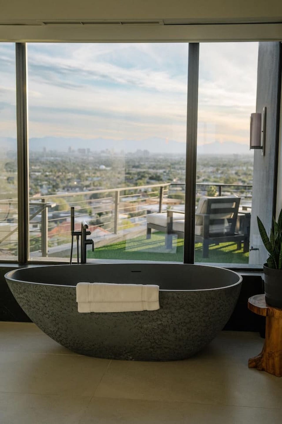 Soak in the luxurious freestanding stone tub while enjoying panoramic city and mountain views through a massive picture window.