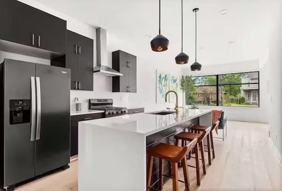 Modern kitchen with a spacious quartz island, bar seating, and updated appliances, designed for easy cooking and gathering. (1st Floor)