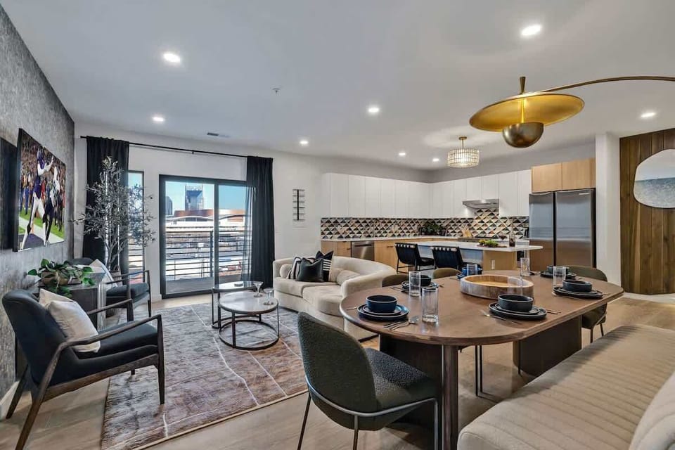Unit 1: Bright open living space featuring smart flat-screen TV, designer furnishings, and access to a large corner private balcony.
