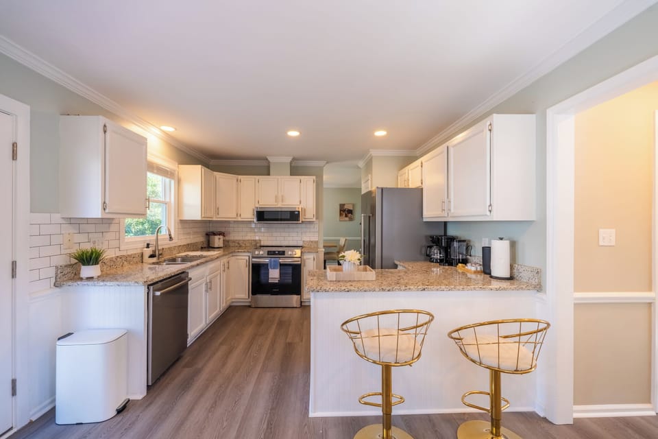 Bright kitchen with granite counters and breakfast bar seating.