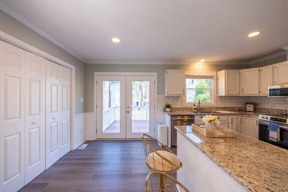 Kitchen with subway tile backsplash and outdoor deck access.