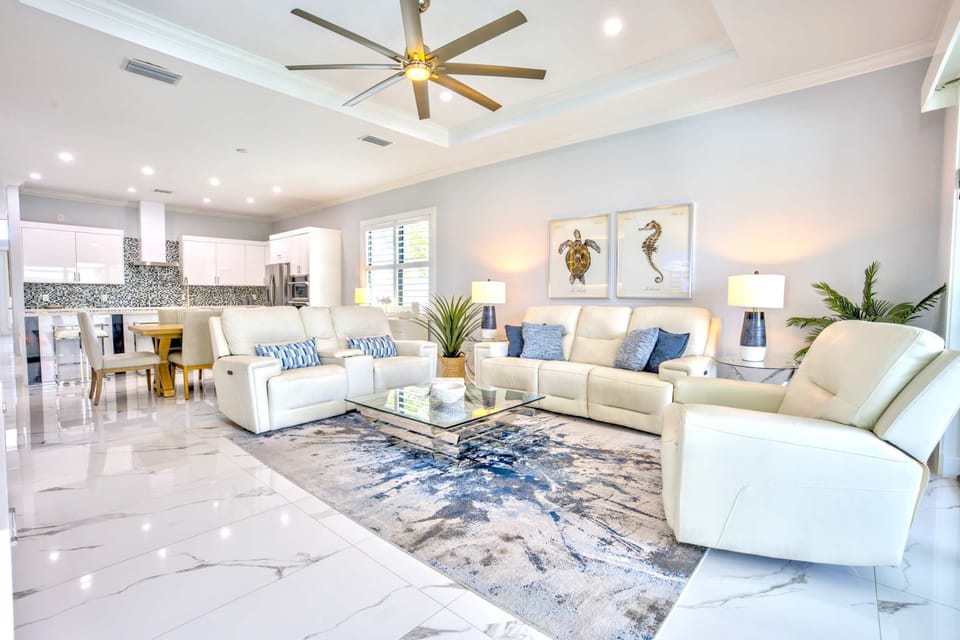 Beautiful Living Room With Cozy Seating Area;  Flat TV;  Large Windows; Entrance to Pool Area;  Perfect Atmosphere For Relaxation And Social Gatherings