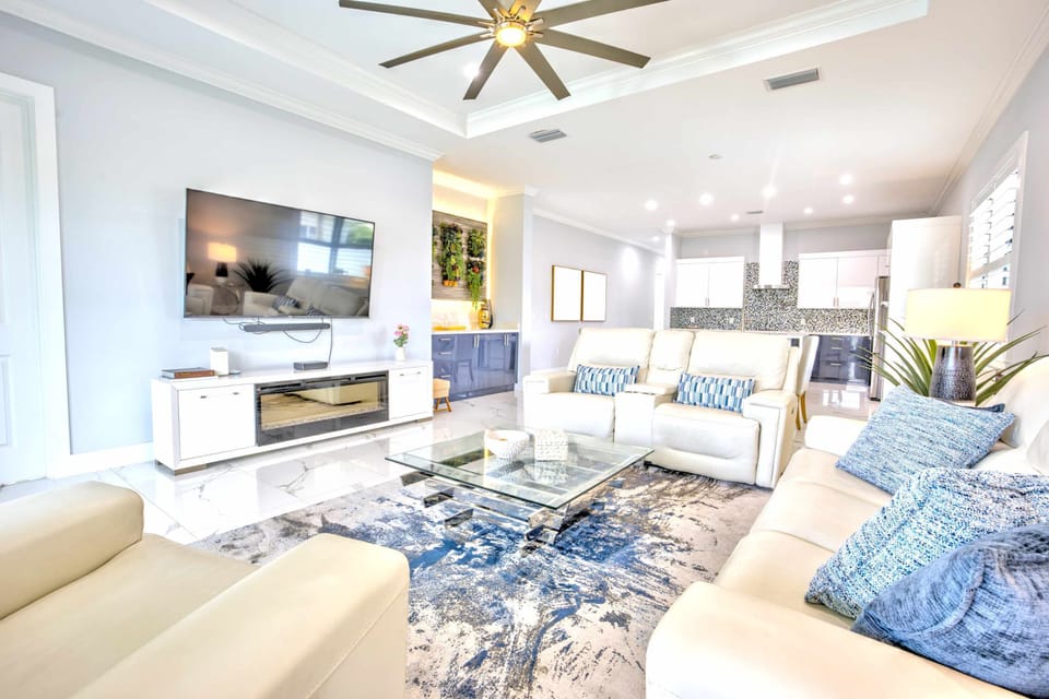 Elegant Living Area; Cozy Sofas, Large TV & Pool Entrance