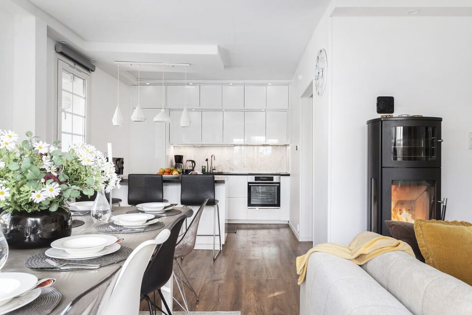 Spacious open layout connecting kitchen, dining table, and living room with fireplace, ideal for families and larger groups.