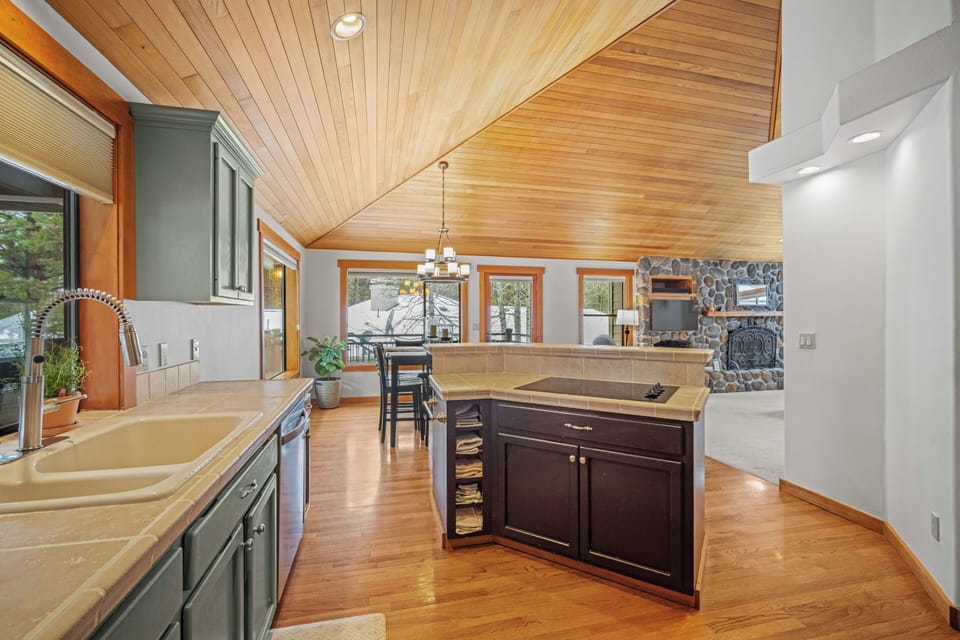 Cook with style in your spacious kitchen featuring warm wood ceilings, granite counters, and a central island perfect for meal prep.