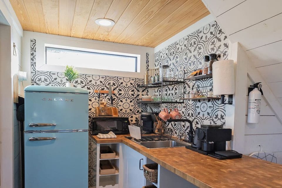 The kitchenette features a fridge, microwave, and coffee station