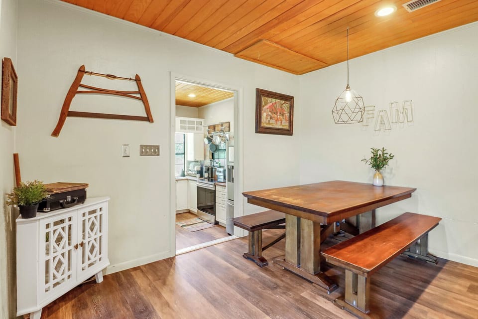 Gather around the handcrafted farmhouse table in this warm dining space, where wood-planked ceilings and thoughtful details create a welcoming setting for shared meals and conversation.