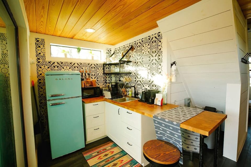 The kitchenette features a fridge, microwave, and coffee station
