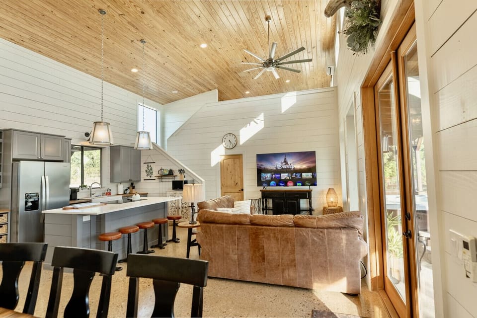The open-concept home combines modern kitchen, cozy living space, and rustic wood ceilings - Hilltop Haven