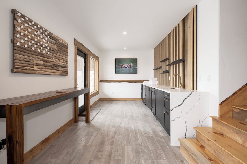 Your sleek kitchen blends modern luxury with mountain charm, featuring stunning marble countertops and warm wood accents.