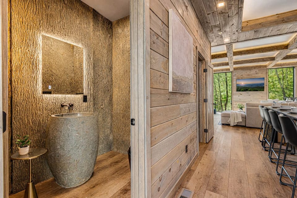 The Hideout's half bath features tree bark walls and a stunning stone sink.